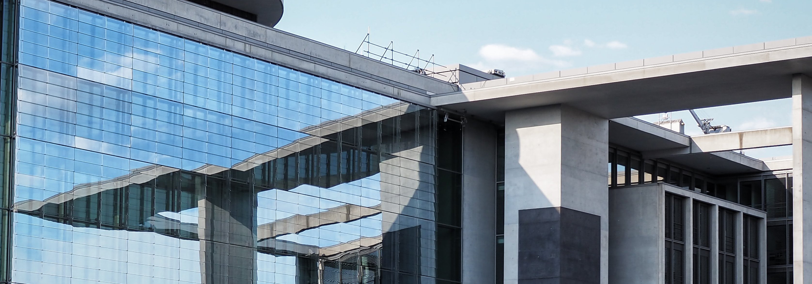 Das Foto zeigt einen Teil eines Gebäudes im Regierungsviertel. Zu sehen ist eine gläserne Fassade und eine hohe Treppe.